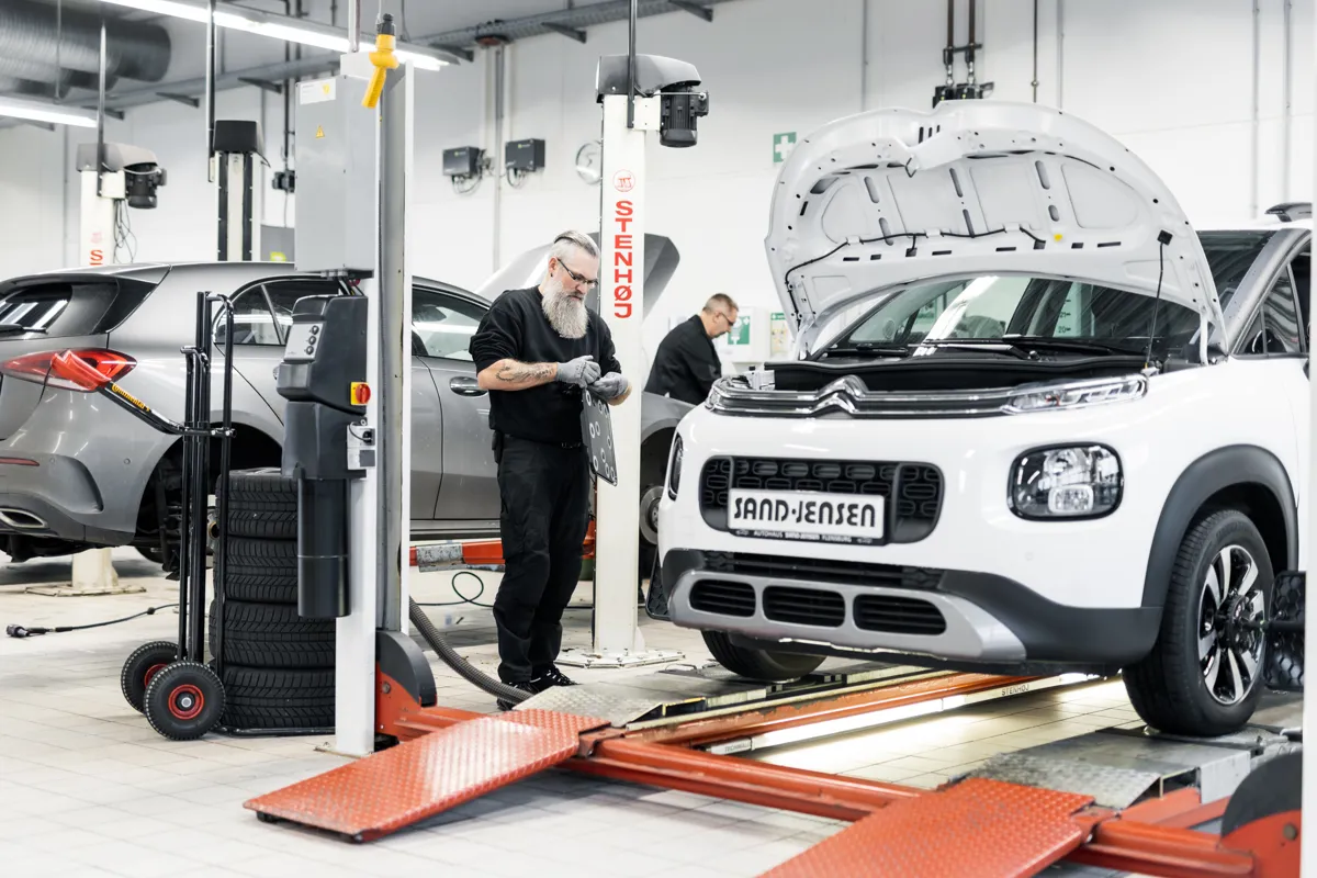 2 Mitarbeiter arbeiten in der Werkstatt an einem Citroën